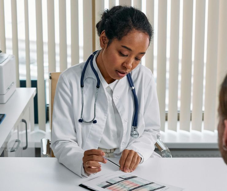 A GP reads a Home Medicines Review and explains the results of the medicine use review to a patient.