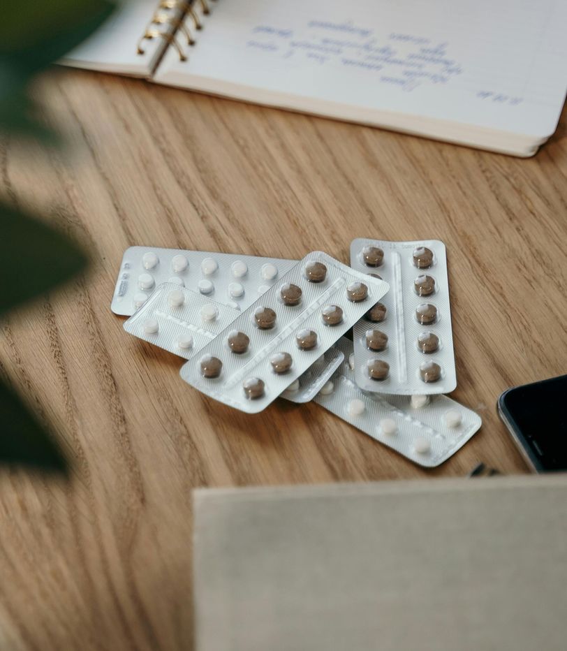 A portrait collection of medicines in blister packs on a bench.