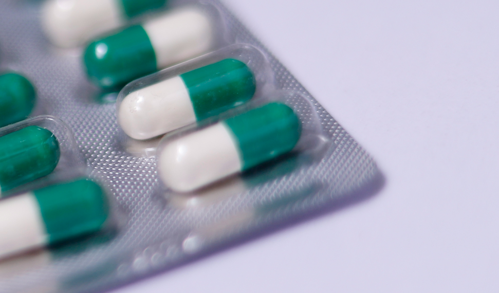 A closeup image of a blister pack containing pills in a child resistant packaging.